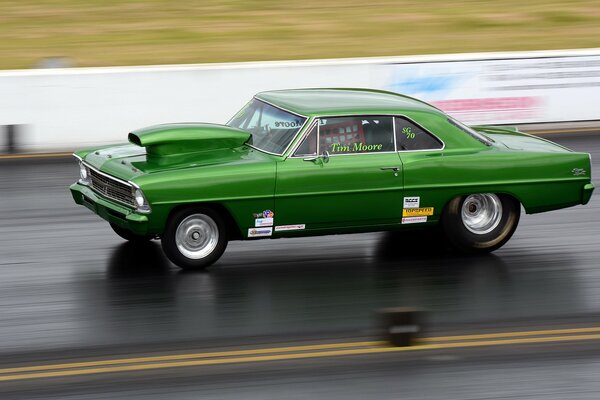 There is a green car of unusual design on the highway