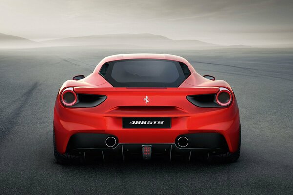 Samochód Ferrari jest czerwony na tle drogi i mgły