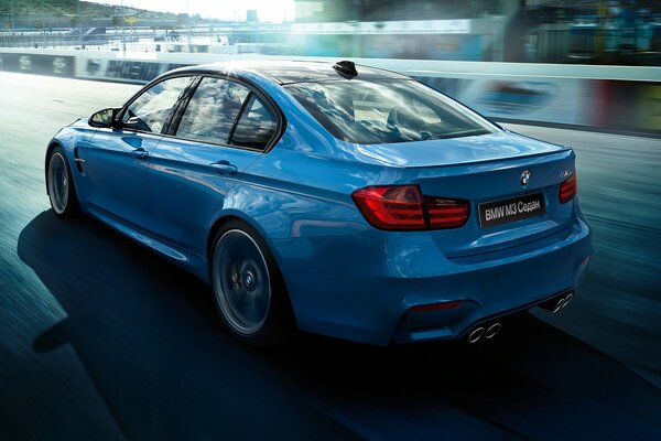 El coche azul de BMW monta en la carretera de carreras