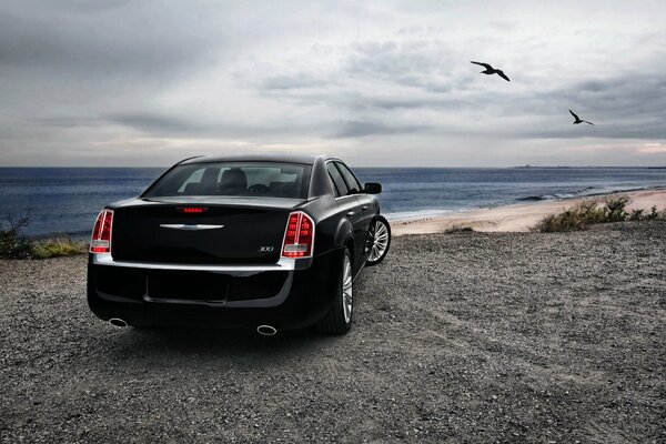 Chrysler sedán negro cerca de la costa