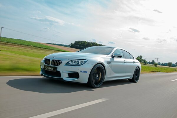 Un bmw blanco corre por la carretera