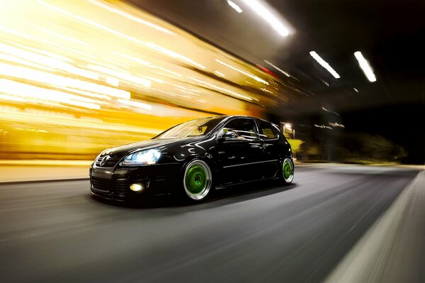 A beautiful black Volkswagen rushes through the night city