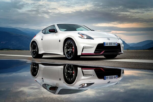 Nissan con el cielo en las nubes y el reflejo en el agua