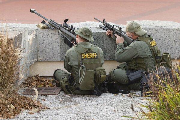 Francotiradores con armas detrás del piso de concreto