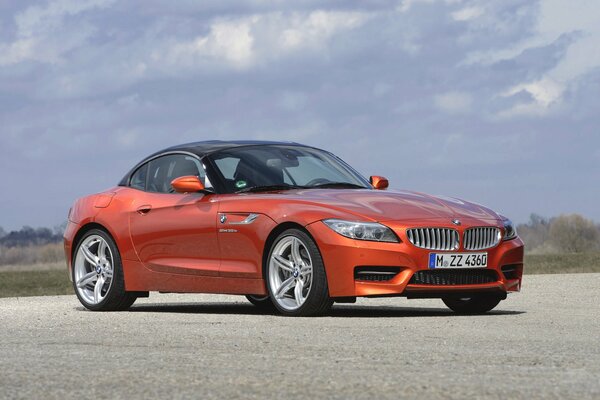 A red BMW car stands against the sky