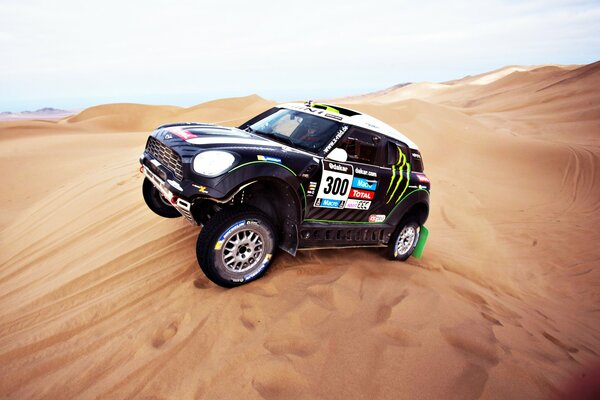 A racing car is driving through a sandy desert