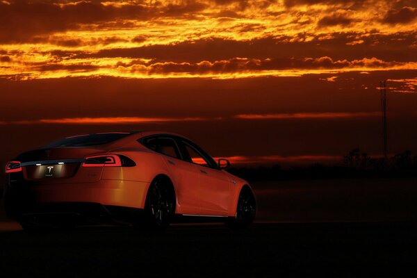 Tesla car on the background of a beautiful sunset