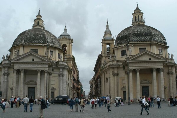 Tourists on the city street near two architectural buildings