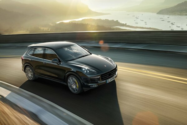 Porsche conduce por la pista, por la tarde en las montañas