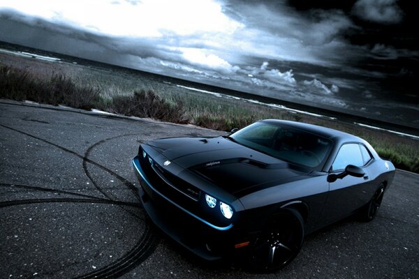 Voiture de couleur noire sur fond de nuages sombres