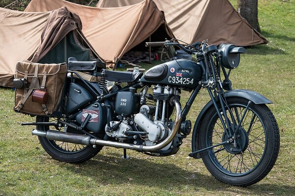 An army motorcycle from the Second World War stands in a field