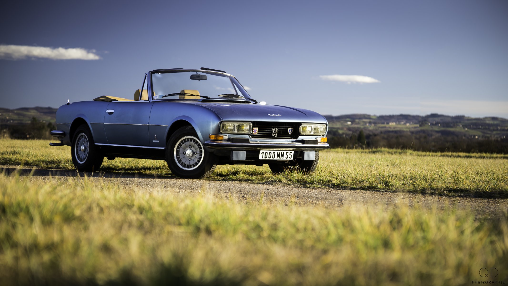 peugeot 504 convertible v6 carretera hierba colinas nubes cielo azul