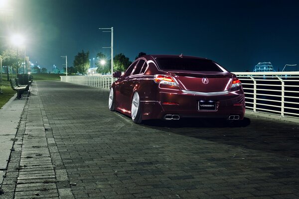 Honda accord burgundy on the background of the evening city