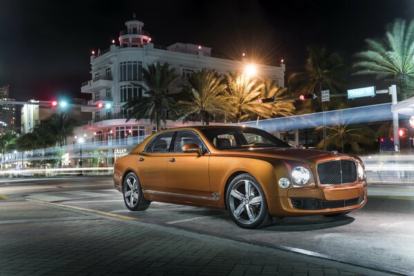 Bentley arancione in mezzo alla città di notte