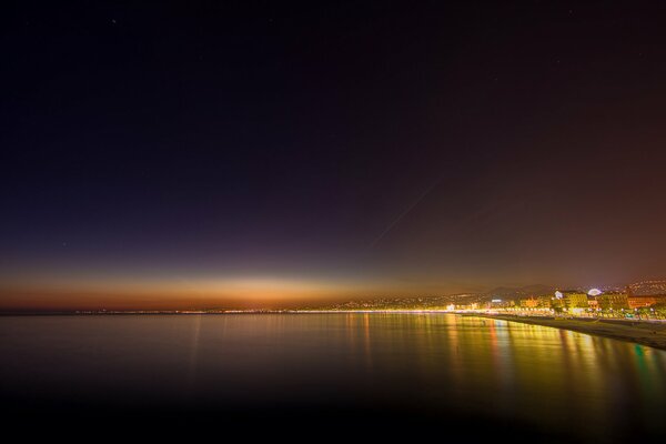 Lustrzana powierzchnia oceanu pod Czarnym nocnym niebem