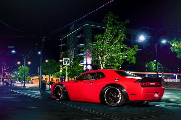 The car is red on the background of a night street