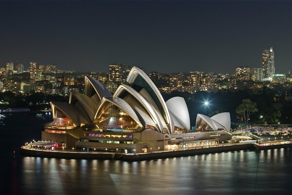 A unique opera house among the evening lights of Australia