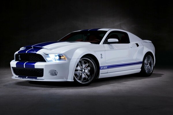 Shelby JT 500 blanco con rayas azules sobre un fondo oscuro