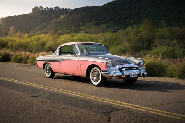 Rosa retrò Studebaker su uno sfondo di colline