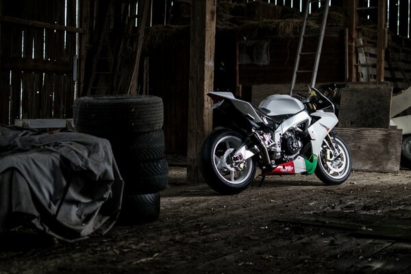 A white motorcycle. Side photo, on the background of tires