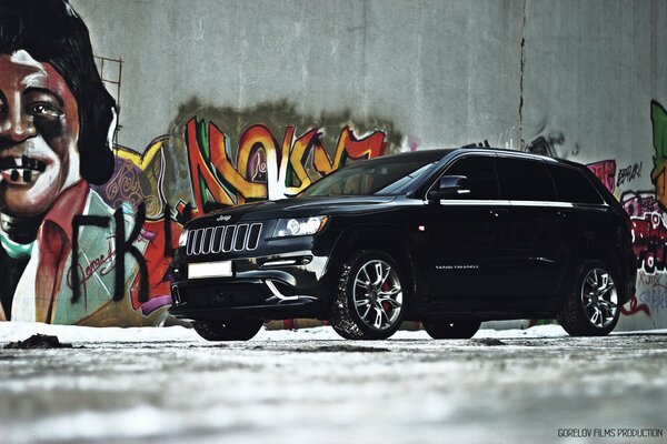 Jeep nera grand cherokee e graffiti sul muro