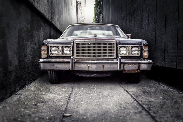 Vieille voiture dans une ruelle sombre