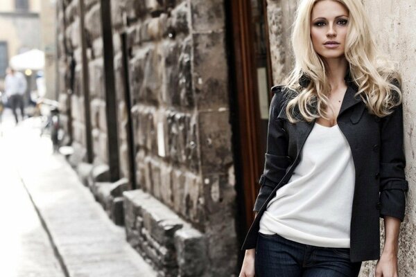 Beautiful girl at the stone wall