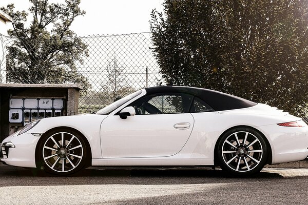 Porsche carrera mit 18-Zoll-Felgen und leuchtend weißer Farbe in einem bogenförmigen Schlafboden