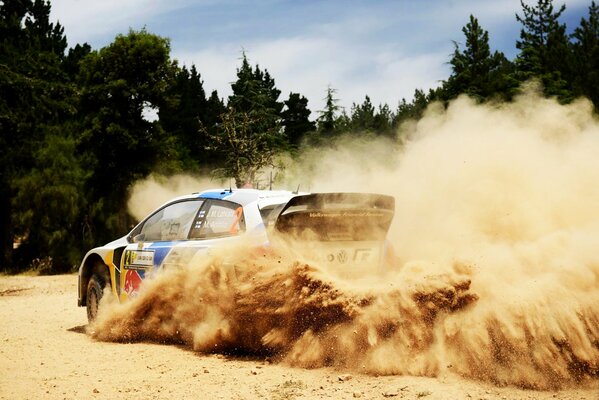 Ein Vw Polo tritt in ein schönes Schleudern im Sand vor einem Wald ein