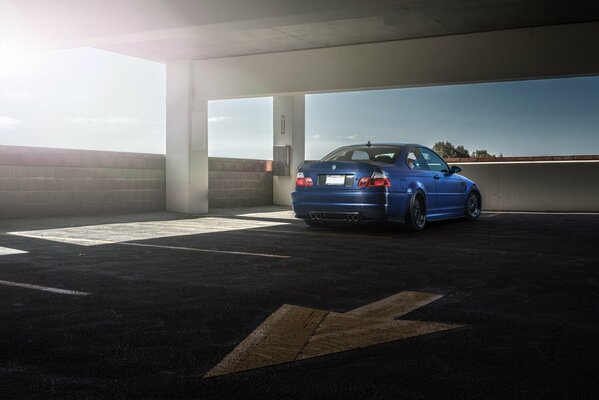 A blue BMW is parked in the parking lot