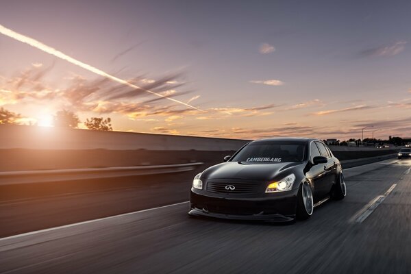 Black tuned infiniti flying down the road