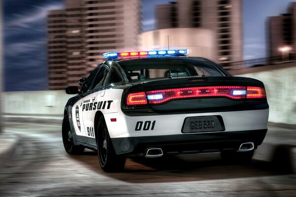 L auto della polizia guida attraverso la città di notte