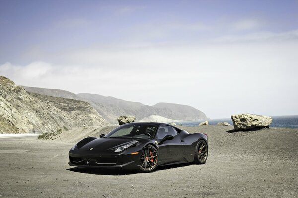 Czarne Ferrari na tle gór i błękitnego nieba