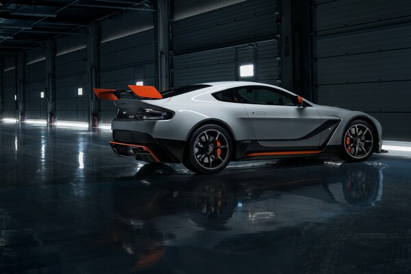 White Aston Martin car with a red stripe on a dark gray background