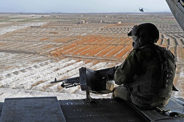 Ein Soldat mit einem Maschinengewehr, der in den Horizont schaut