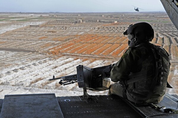 Солдат с пулеметом смотрящий в горизонт