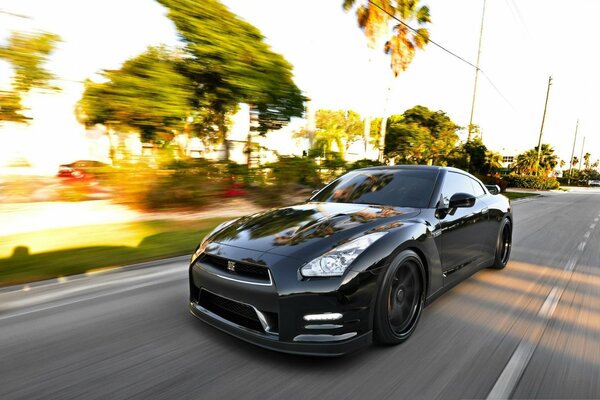 A black Nissan is racing down the road