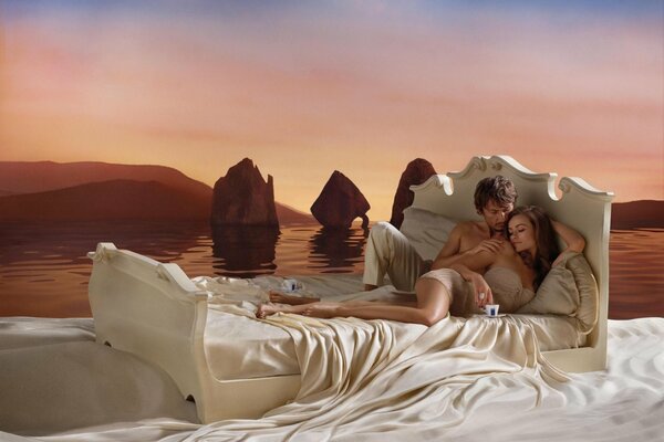 Bett auf dem Hintergrund der Meeresoberfläche. Liebespaar auf weißen Laken