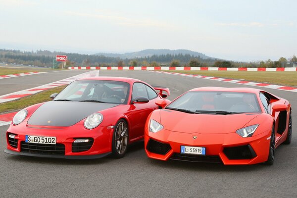 Dwa czerwone samochody Porsche, Lamborghini