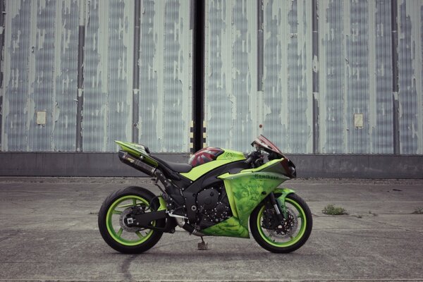 Grünes Motorrad an der Wand