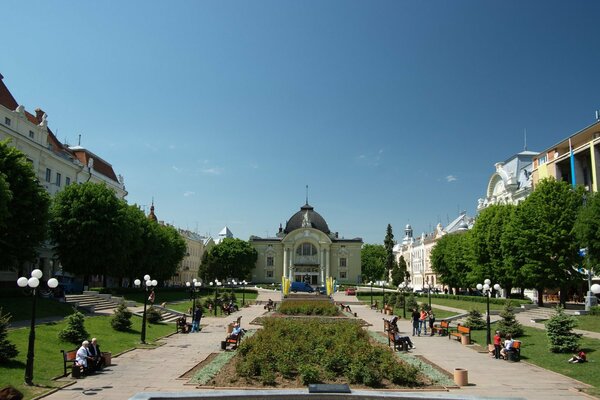 Aleja przed wejściem do teatru z dużymi klombami