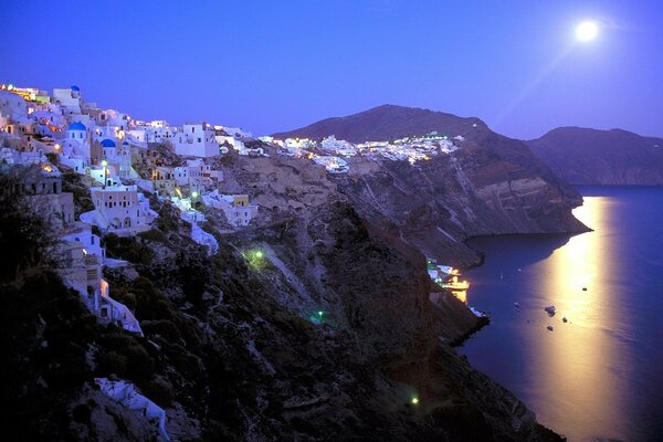 Casas blancas como la nieve en las rocas iluminadas por la Luna