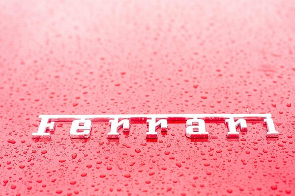 Логотип феррари в каплях дождя на автомобиле