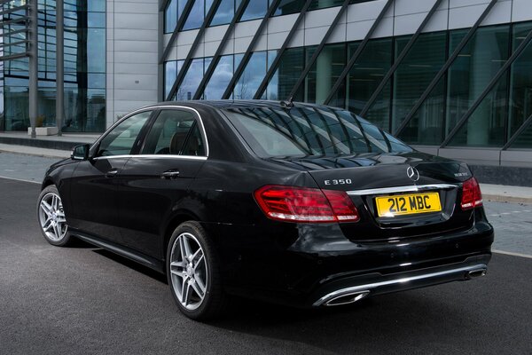 Mercedes-Benzes e 350 black parked on the road next to the office building