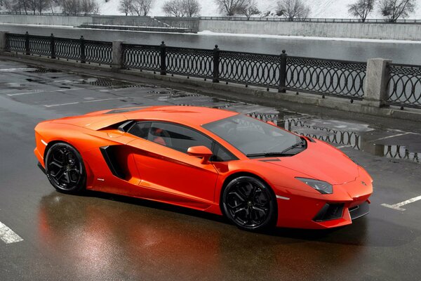 Roter Lamborghini auf einer Brücke in der Nähe des Flusses