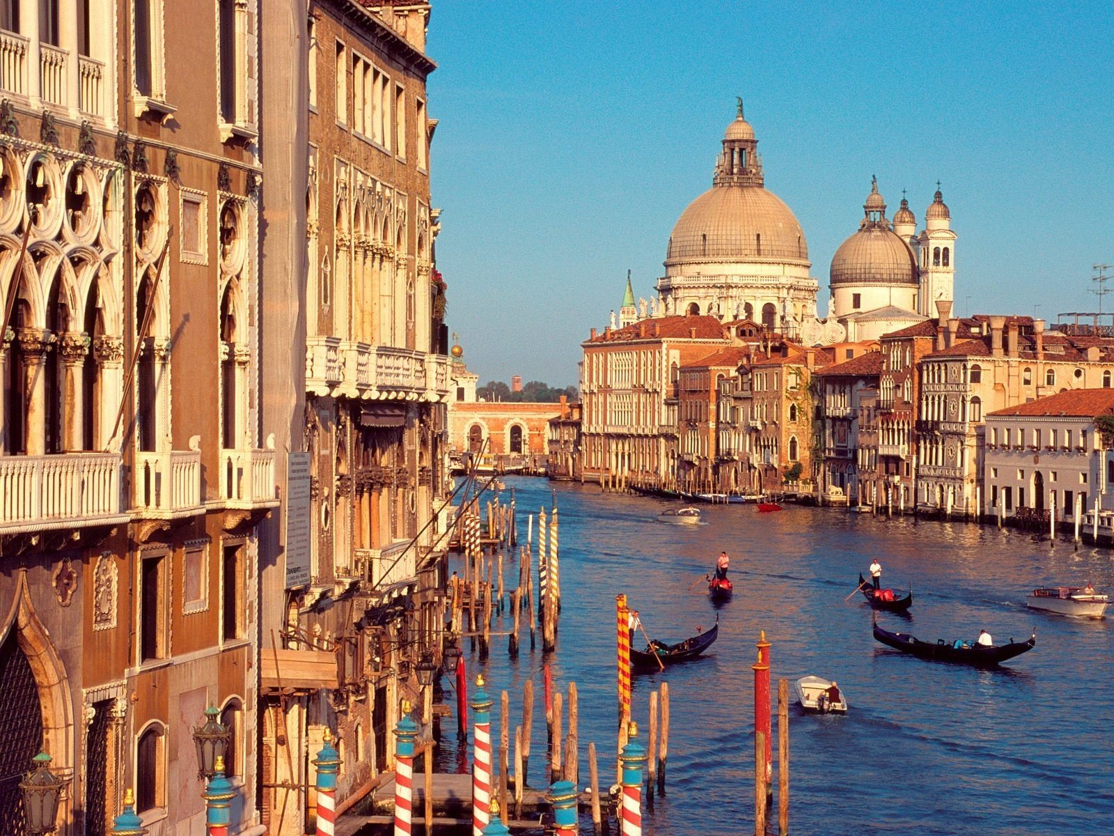 italy venice canal buildings gondolas sky water river sunlight boats pillars windows domes cities morning gondola current boat house