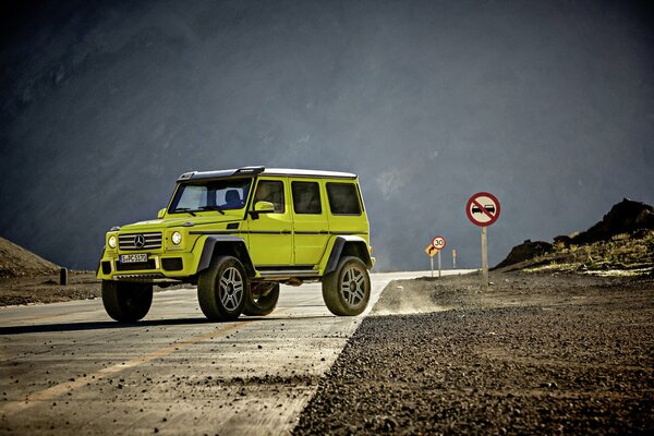 Green Mercedes Benz in brabus body kits on a mountain road