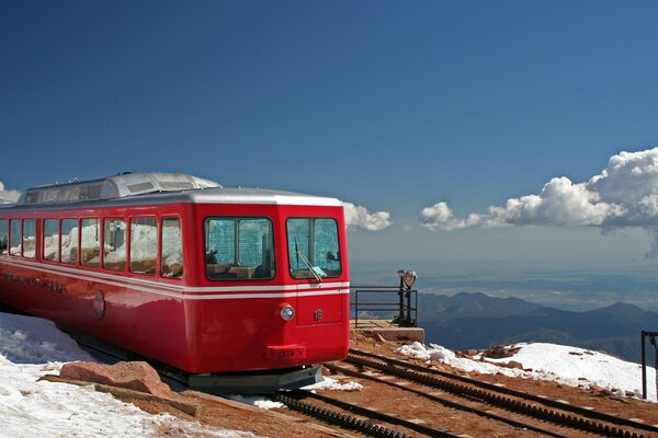 Tren en el ferrocarril en el fondo del paisaje de montaña