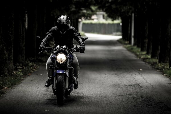 Biker im Helm auf einem Motorrad fährt auf der Straße