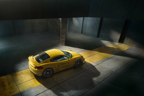 Porsche Cayman jaune dans la pénombre